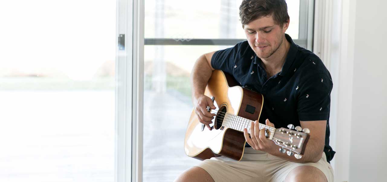 Man playing guitar at home