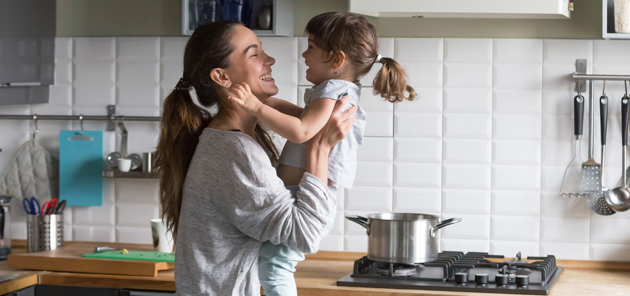 mother playing with daughter in kitchen