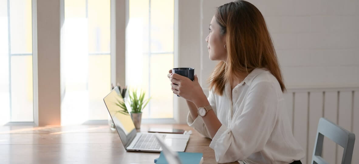 woman drinking coffee while working