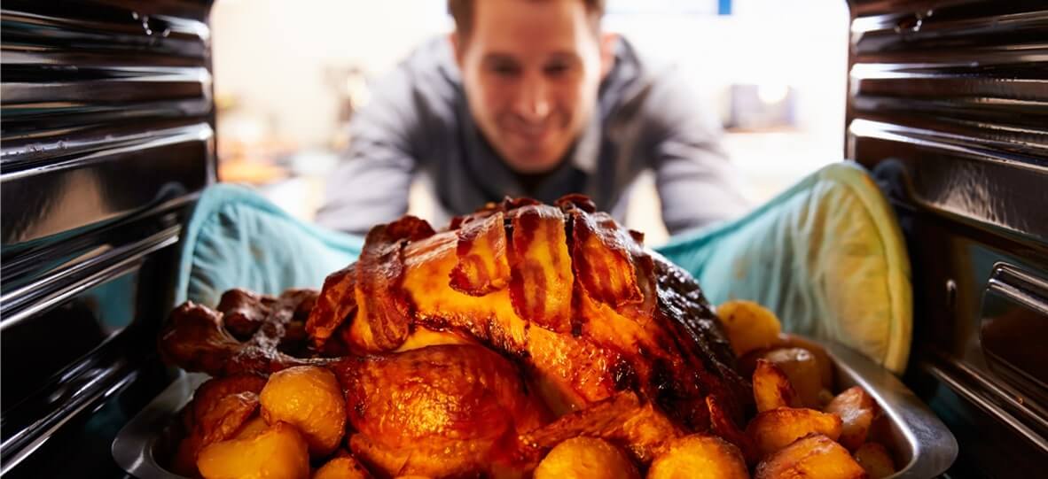 Man taking turkey out of oven